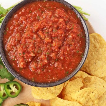 Homemade salsa on a wooden platter with tortilla chips