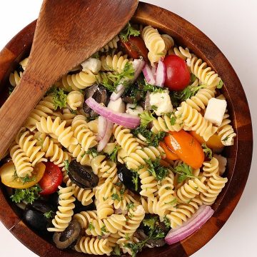 Finished salad in a wooden salad bowl with wooden spoon