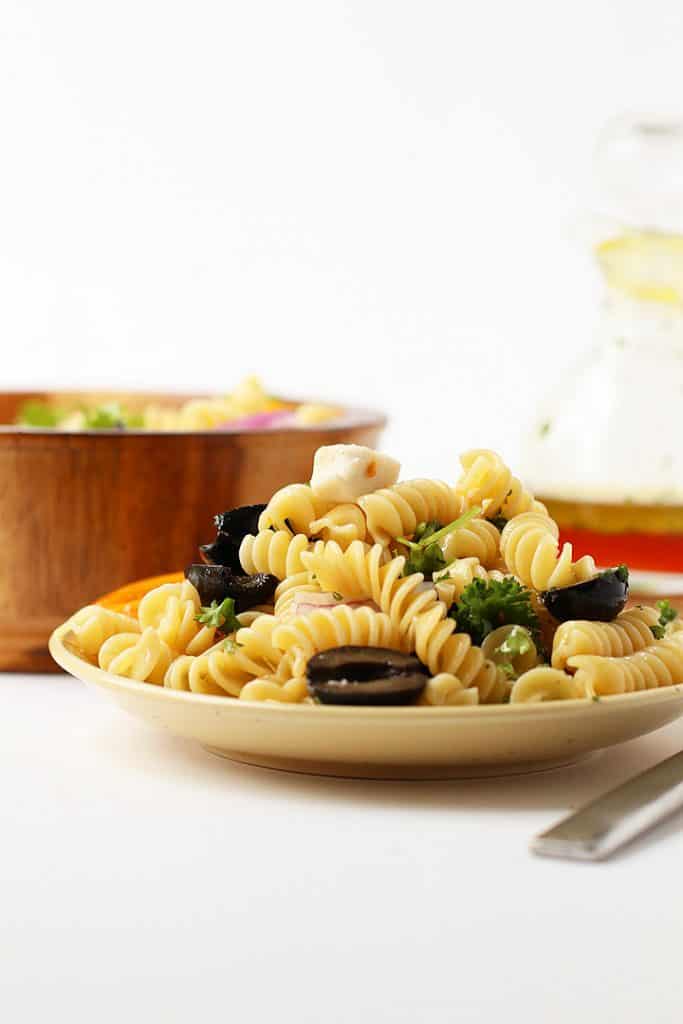 A white plate of potluck friendly vegan pasta salad
