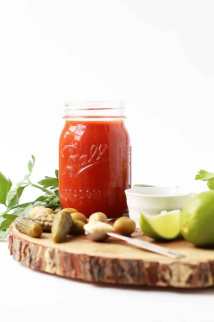 Tomato juice in a small Mason Jar next to pickles