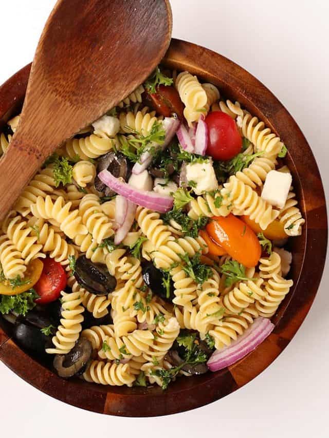 Finished salad in a wooden salad bowl with wooden spoon