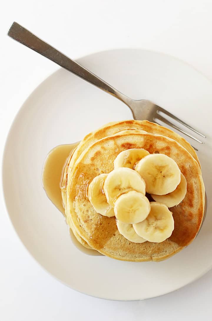 Overhead shot of vegan pancakes with sliced bananas