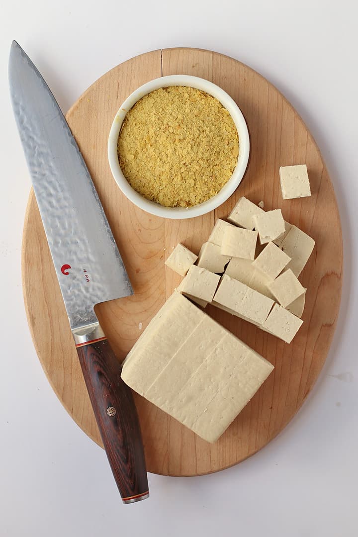 cubed tofu and nutritional yeast on a wooden platter
