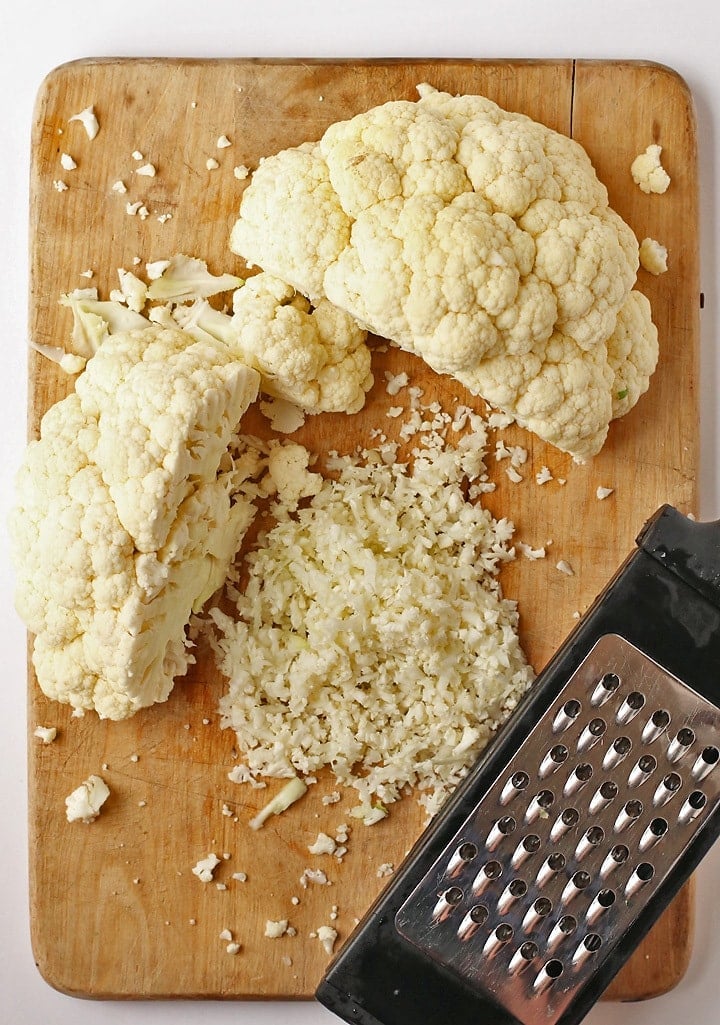 Head of cauliflower cut in half on a cutting board