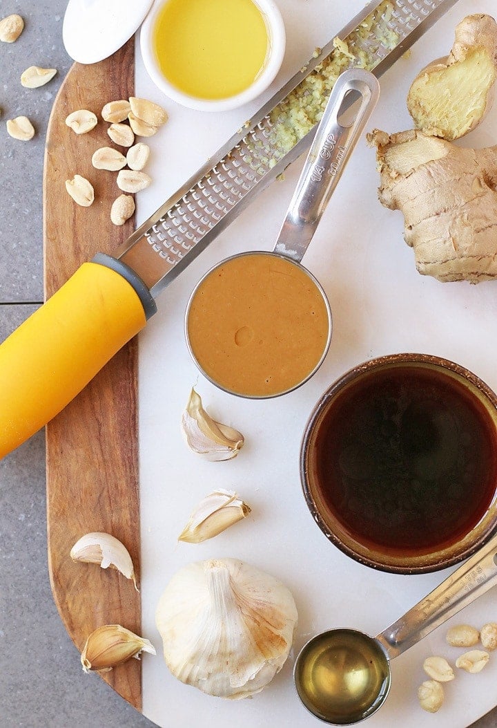 Peanut butter, soy sauce, garlic, and ginger on a marble board
