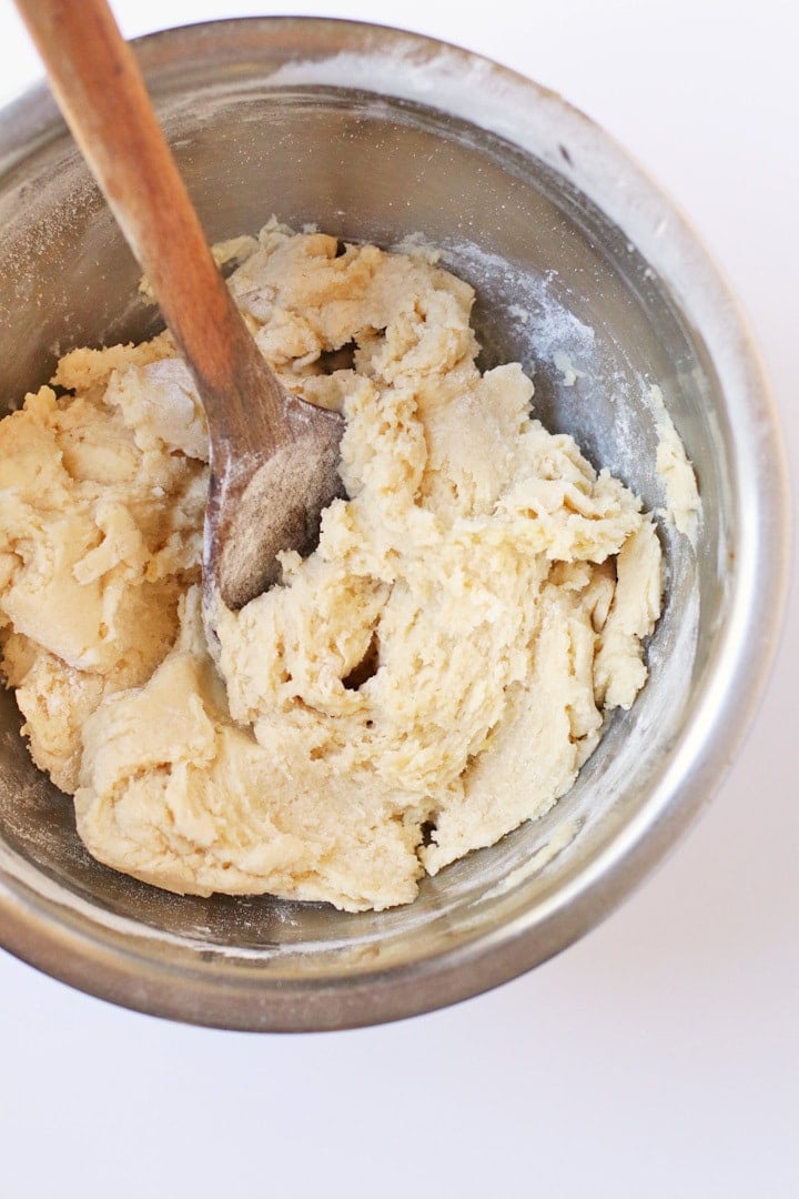 Cookie dough in a metal bowl with a spoon