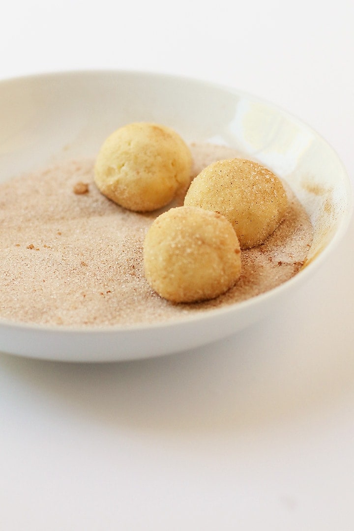 Cookies dough rolled into balls and placed in cinnamon sugar