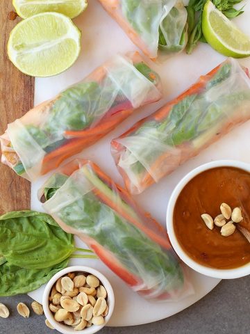 Finished spring rolls on a platter with peanut sauce