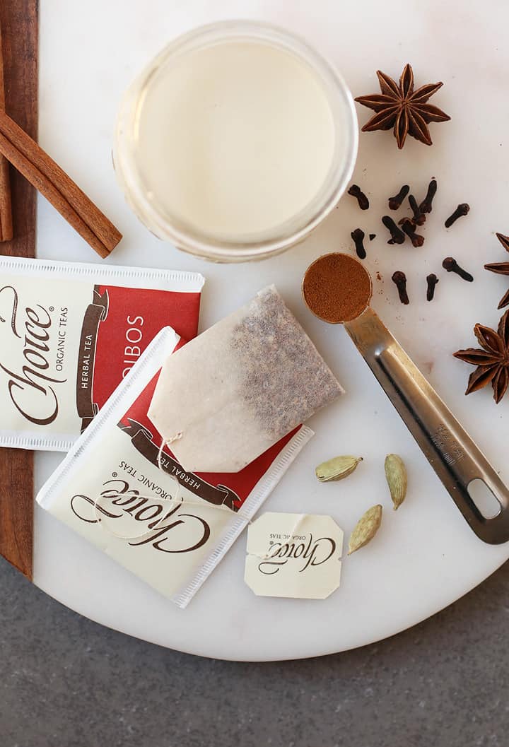 Milk, spices, and tea bags on a marble platter