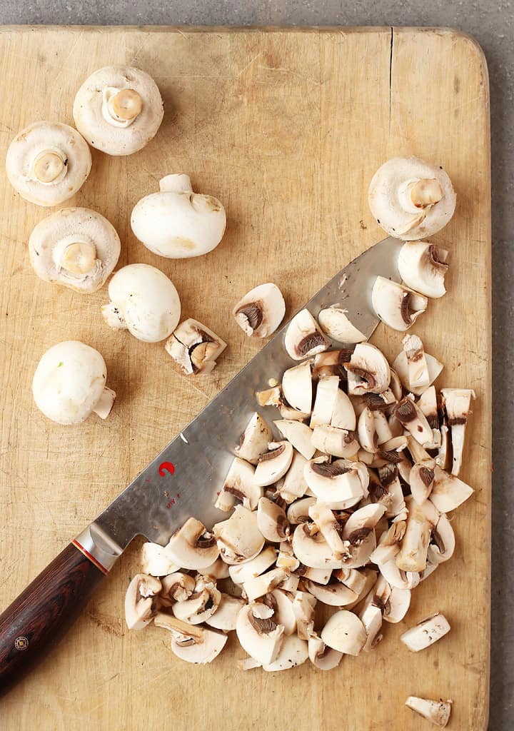 Chopped button mushrooms on a cutting board