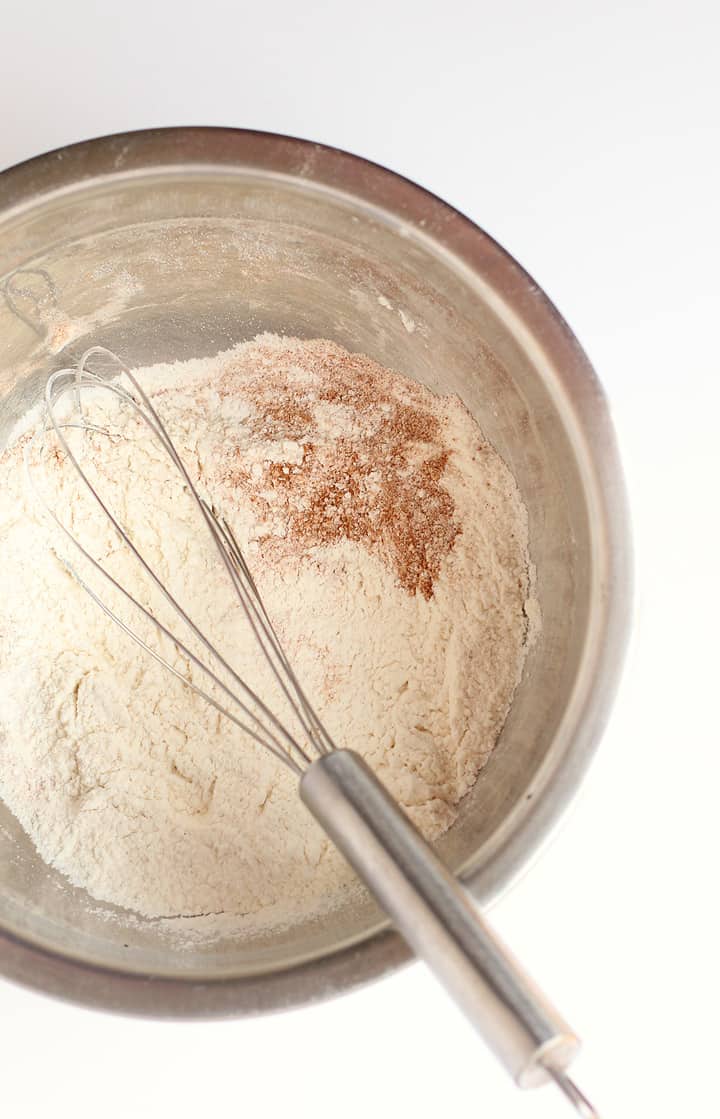 Dry ingredients for Ginger Molasses Cookies in a metal bowl with a whisk. 