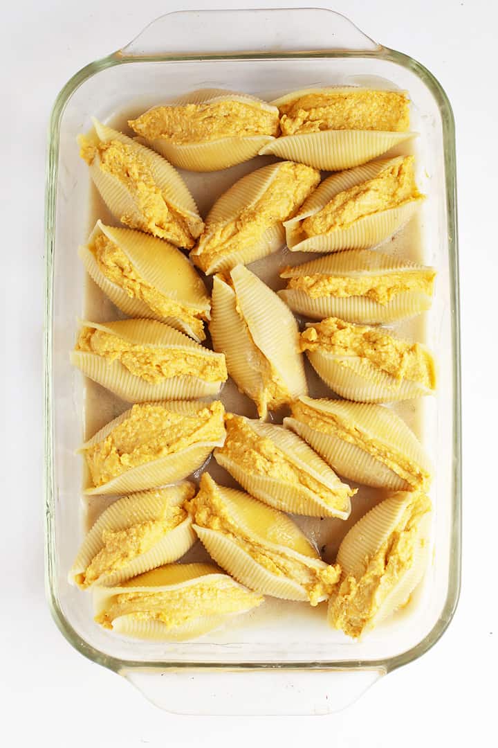 Raw pumpkin stuffed shells in a casserole dish