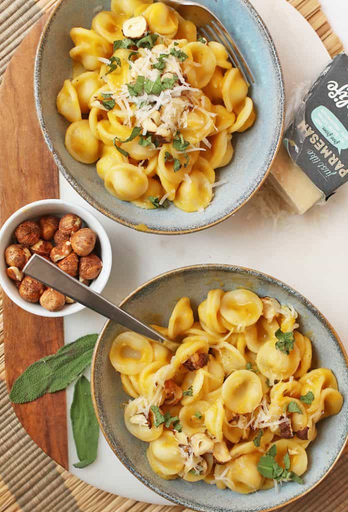 Two bowls of creamy Butternut Squash Pasta with toasted hazelnuts.