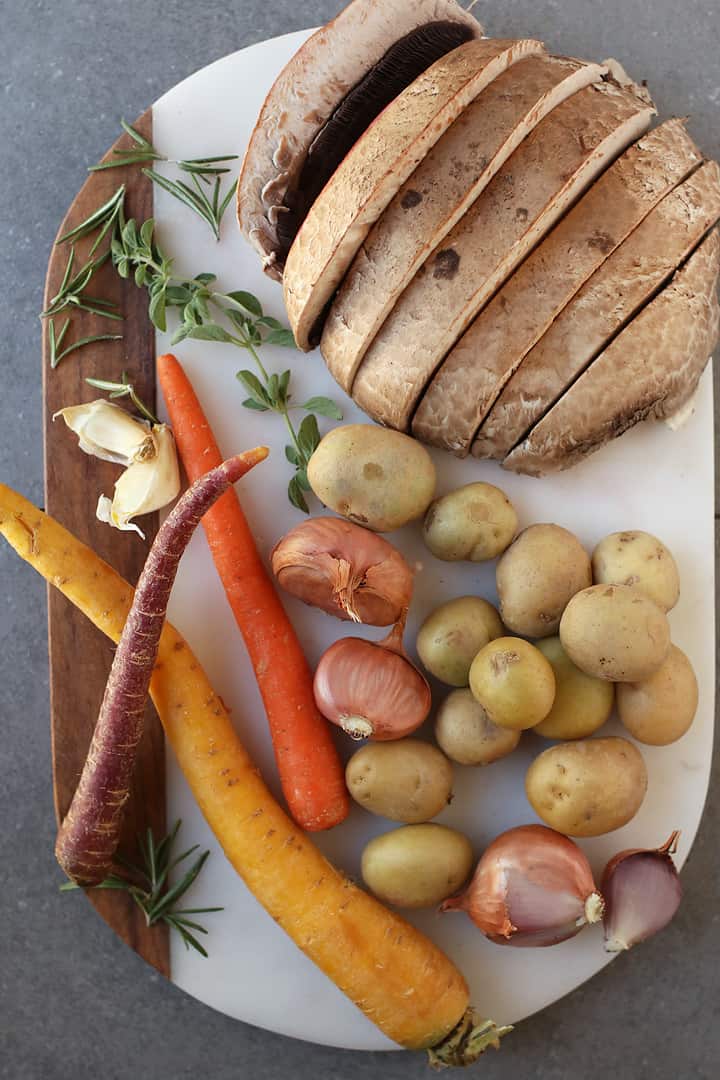 Mushrooms, potatoes, carrots, and garlic on cutting board