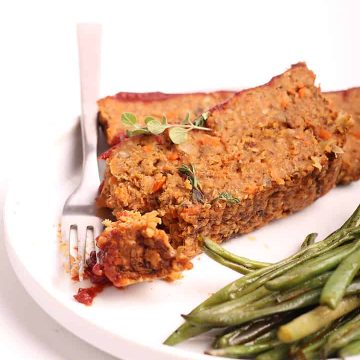 Two slices of vegan meatloaf on a white plate