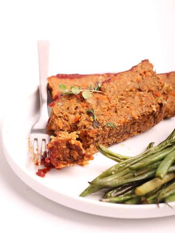 Two slices of vegan meatloaf on a white plate