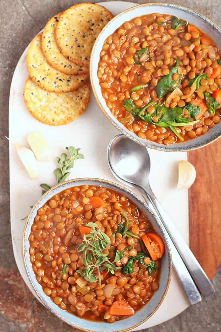 Two bowls of lentil soup on a marble board