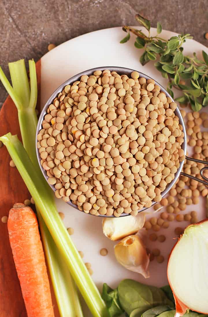 Dried lentils, celery, and carrots on cutting booard