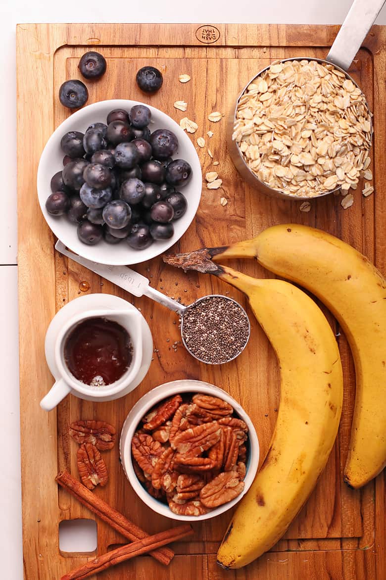Bananas, oats, and blueberries on a cutting board