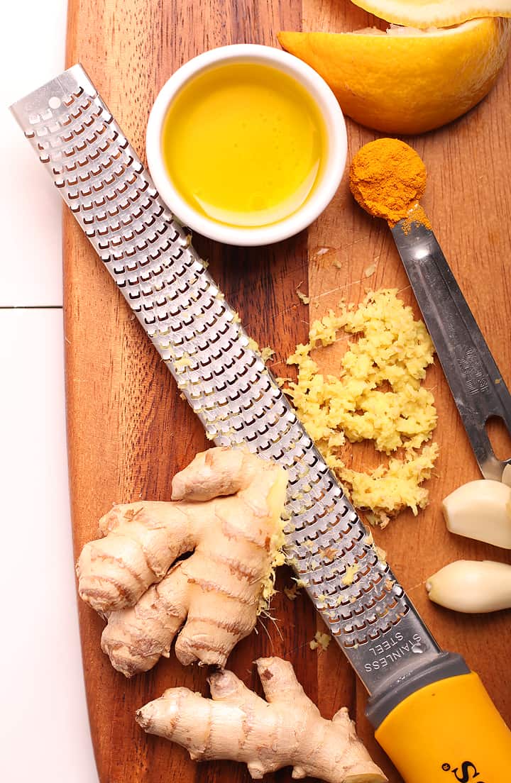 Grated ginger, garlic, and olive oil on a cutting board