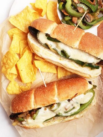 Vegan Philly Cheesecake sandwiches on platter with chips