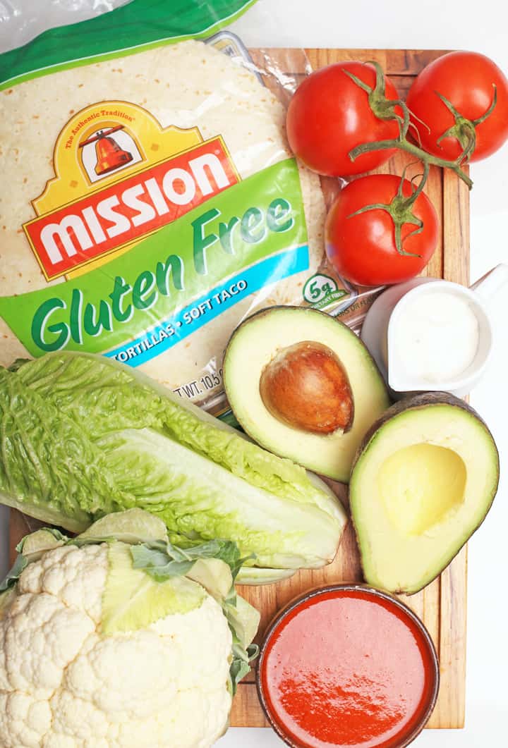 Lettuce, avocado, and tomatoes on cutting board