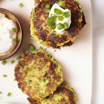 Stack of vegan zucchini fritters with sour cream