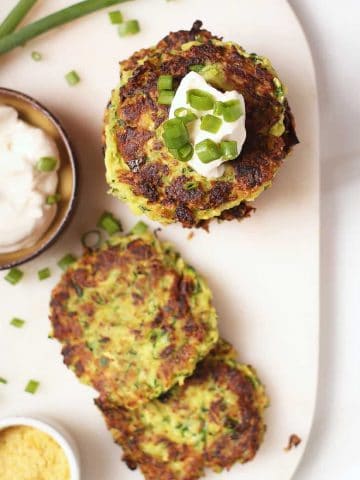 Stack of vegan zucchini fritters with sour cream