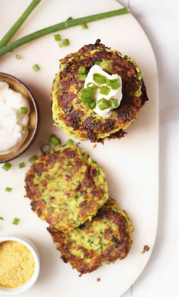 Stack of vegan zucchini fritters with sour cream