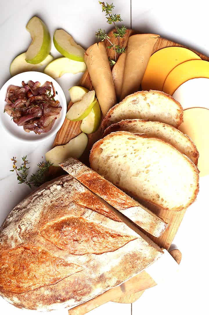 Bread, cheese, and apples on cutting board