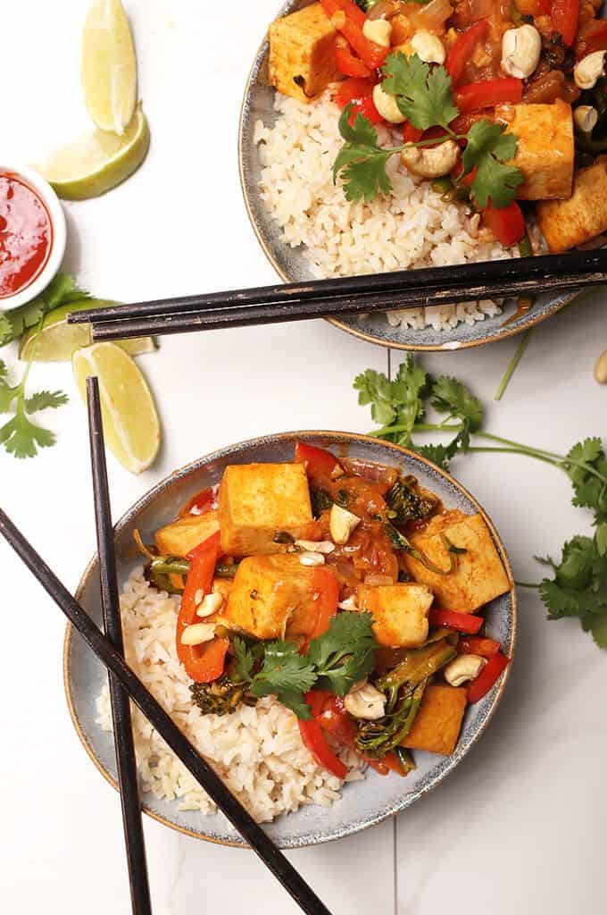 Easy weeknight Coconut curry with tofu over rice on a white background
