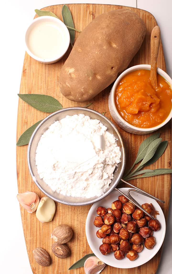 Flour, potatoes, pumpkin, and hazelnuts on wooden board