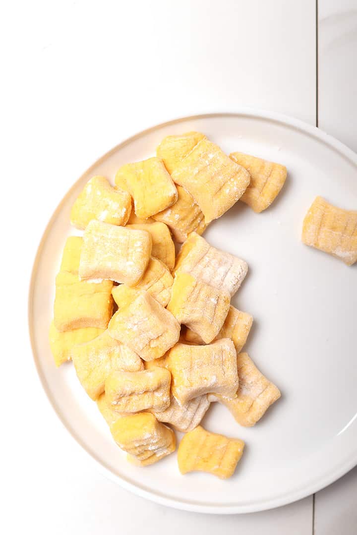 Raw pumpkin gnocchi on white plate