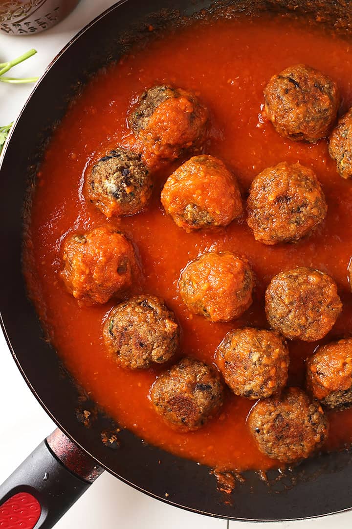 Vegetarian meatballs simmering in marinara sauce