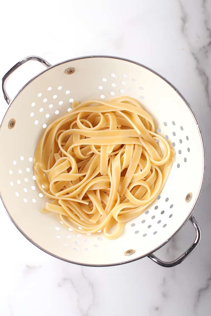 Fettuccine noodles in a white colander