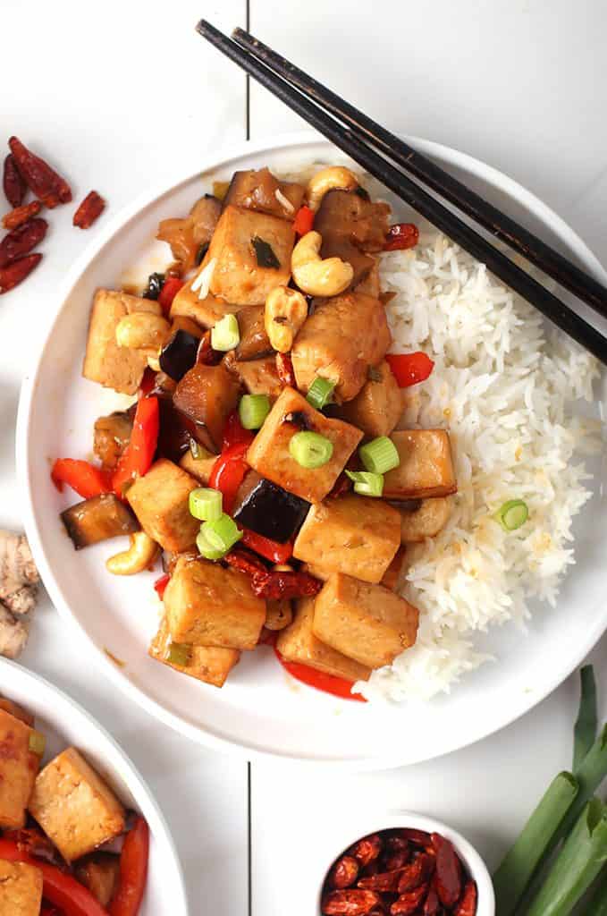 Kung Pao Tofu on white plate with rice and chopsticks