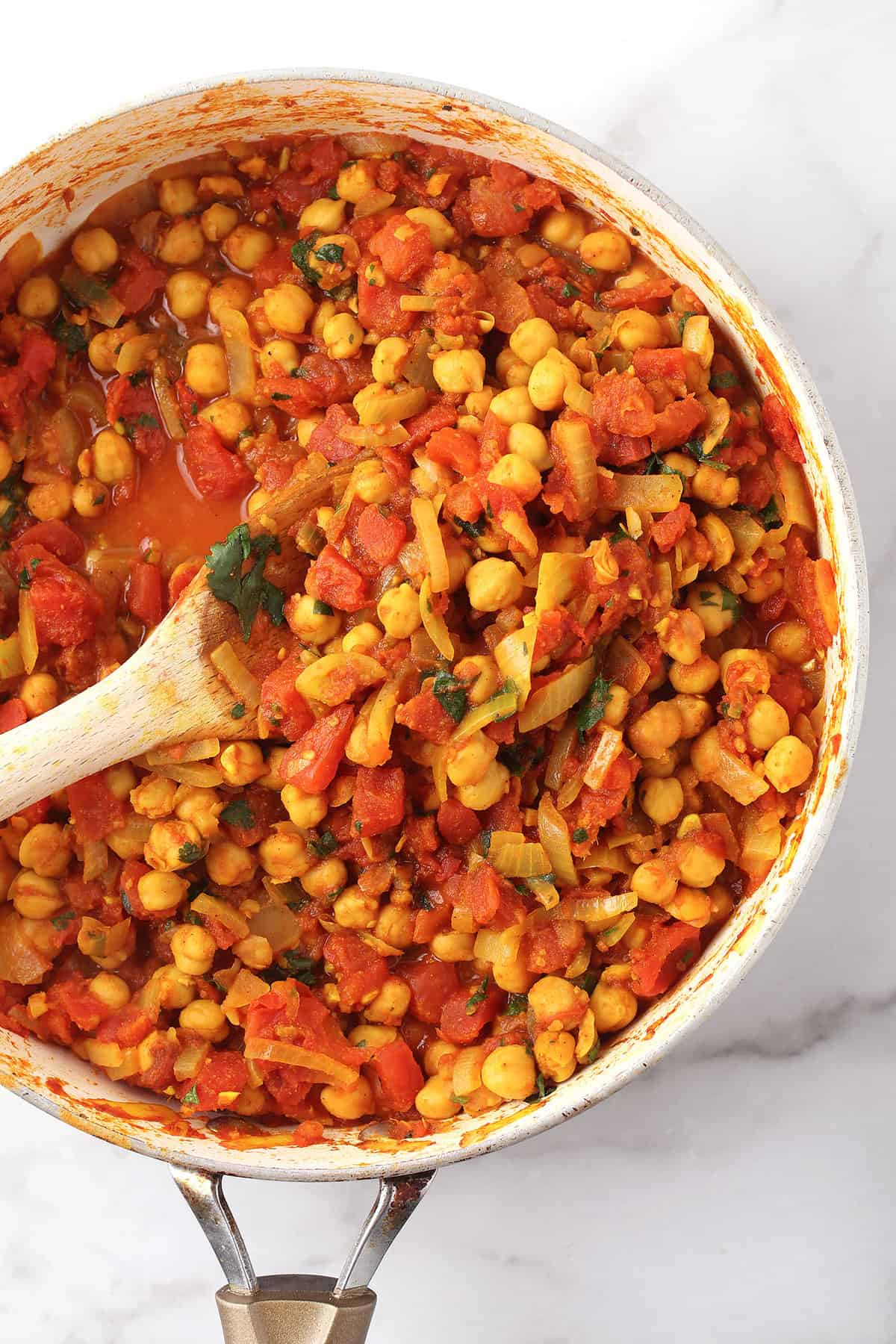 Chickpeas and tomatoes in a large sauté pan