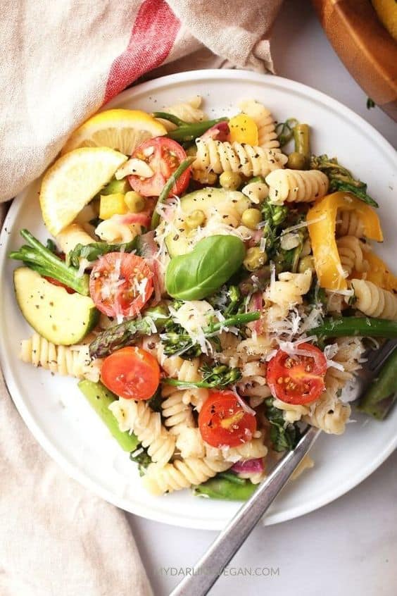 Vegan pasta on a white plate with a fork on table