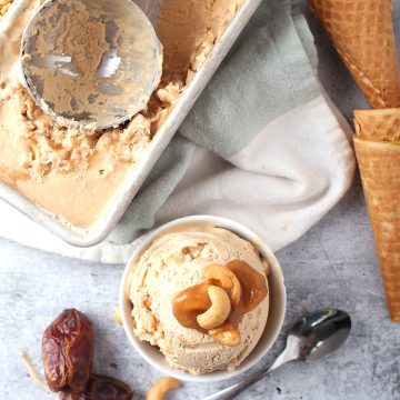 Finished ice cream in a white bowl next to cones