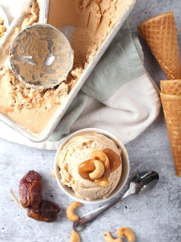 Finished ice cream in a white bowl next to cones