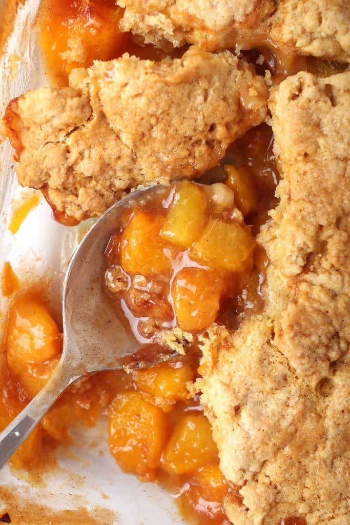 Close up of finished cobbler with a serving spoon