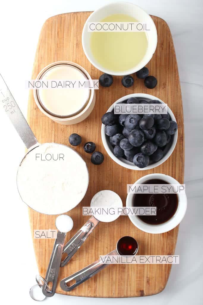 Blueberries, flour, oil, and maple syrup on a wooden board