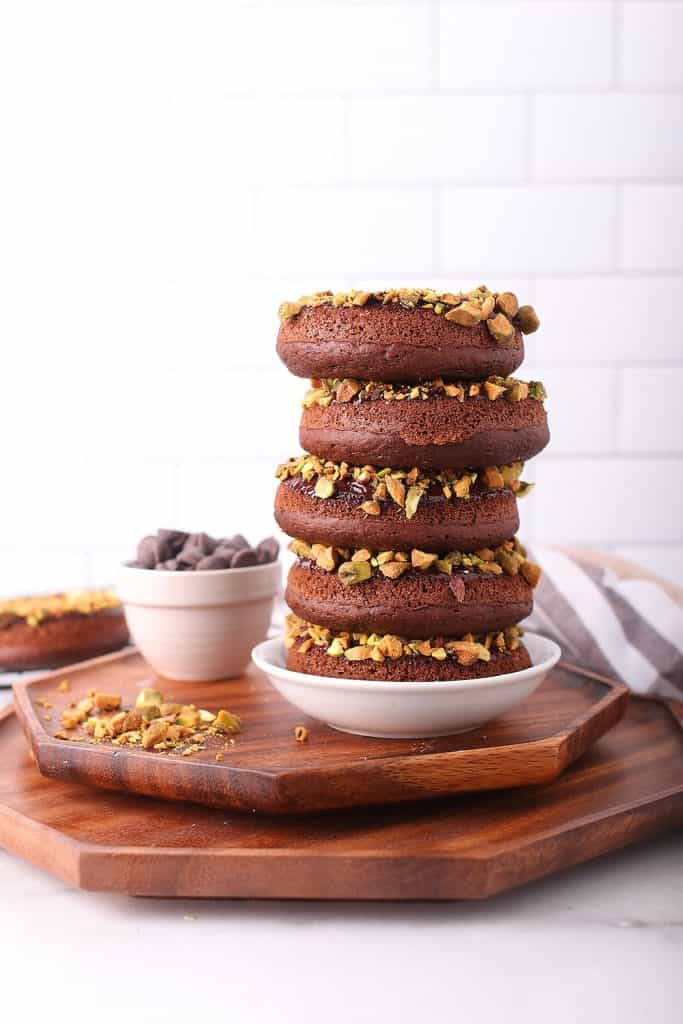 Stack of chocolate doughnuts on a wooden platter