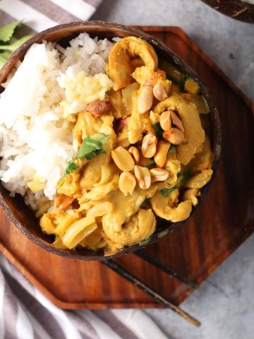 Finished dish served over rice in a coconut bowl