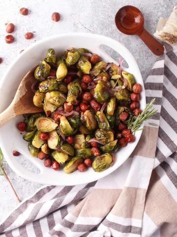 Roasted brussels sprouts and hazelnuts in a white bowl