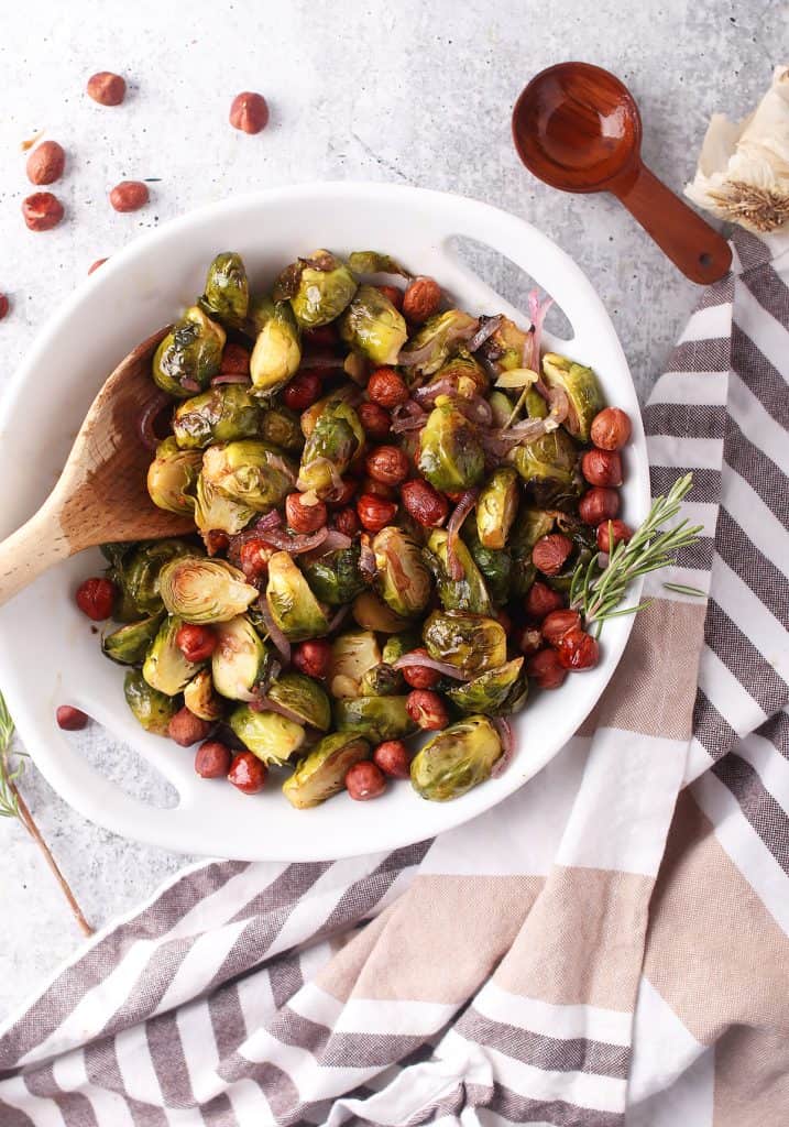 Roasted brussels sprouts and hazelnuts in a white bowl