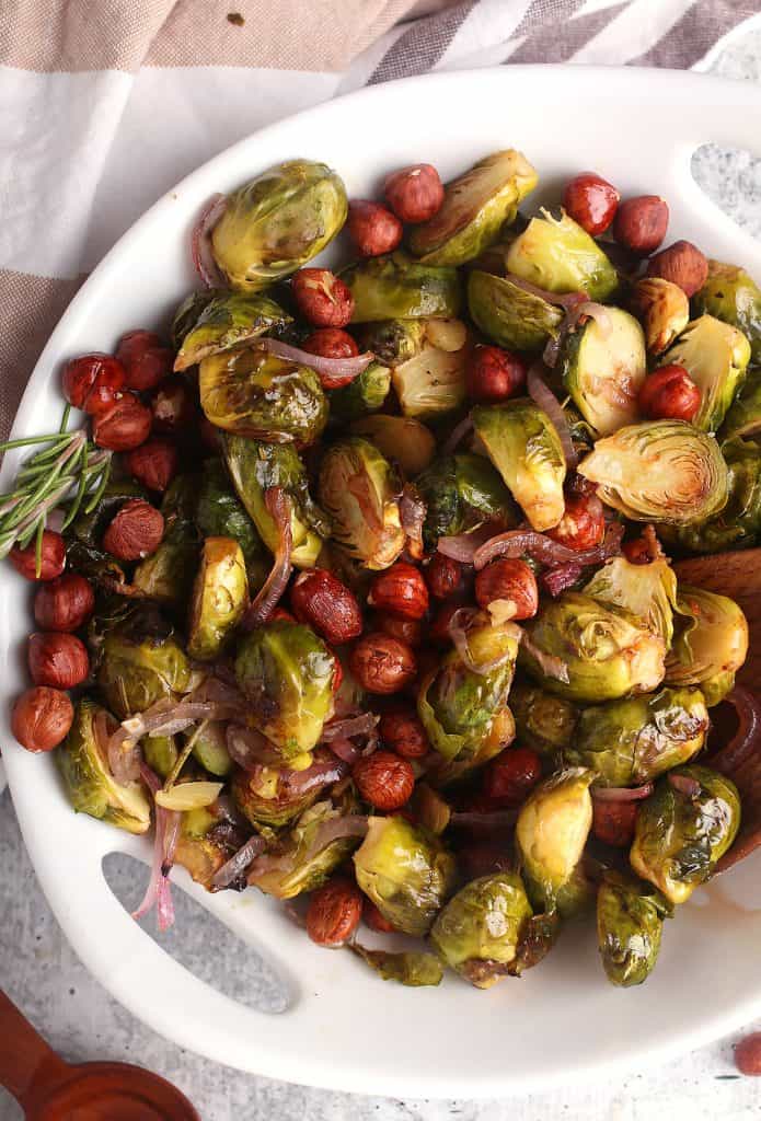 Roasted brussels sprouts and hazelnuts in a white bowl