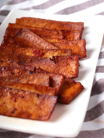 Strips of vegan bacon on a white plate