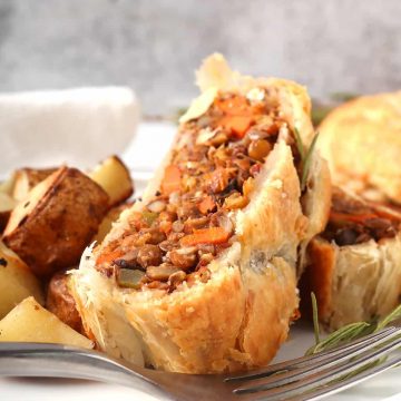 Slice of vegan Wellington on a white plate