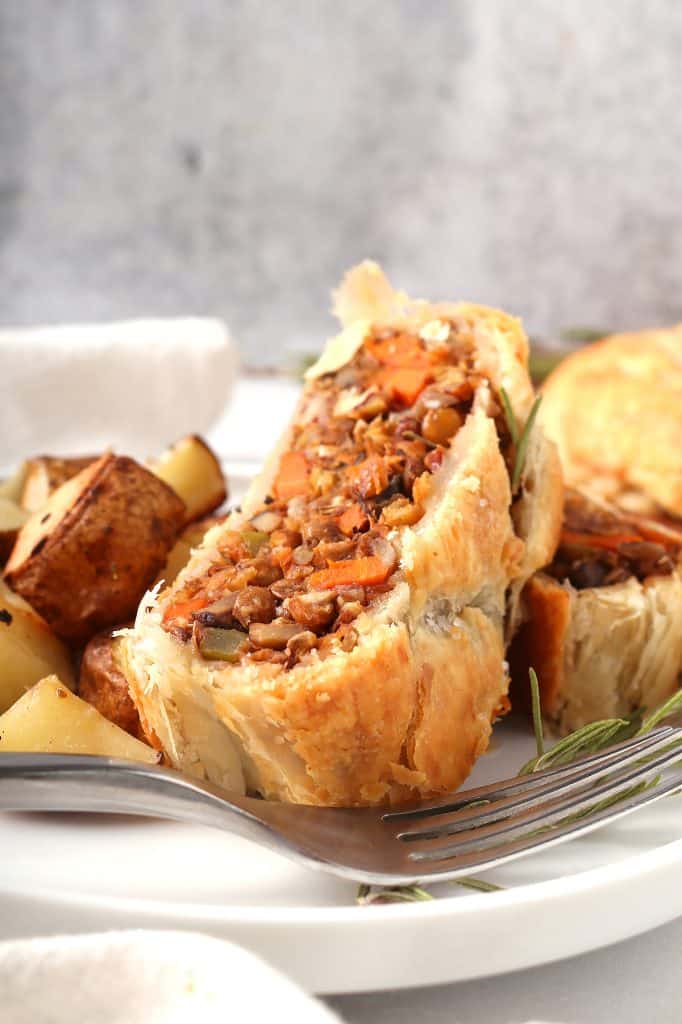 Slice of vegan Wellington on a white plate
